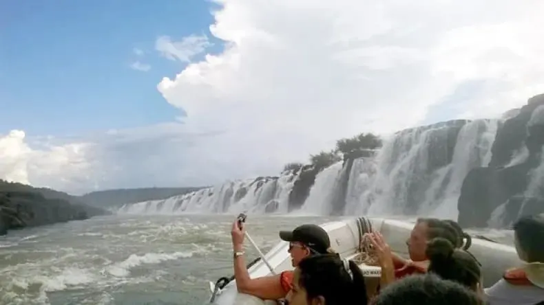 Turistas en lancha frente a los Saltos del Moconá, apreciando las enormes cascadas longitudinales sobre el río Uruguay