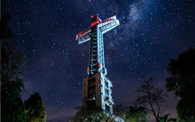 Parque Temático de la Cruz en Santa Ana iluminado de noche bajo un cielo estrellado