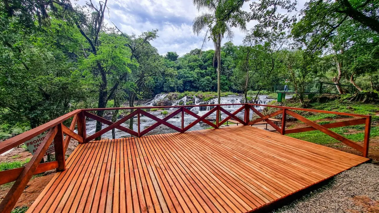 Deck de madera rojo con vista a las cascadas del Tabay y selva al fondo