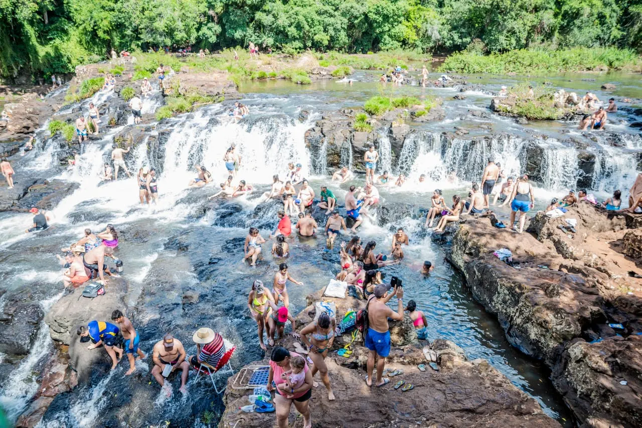 Turistas y familias disfrutando y bañándose en las cascadas del Tabay en verano